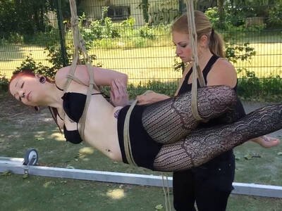 Rothaarige Deutsche lässt sich im Garten fesseln