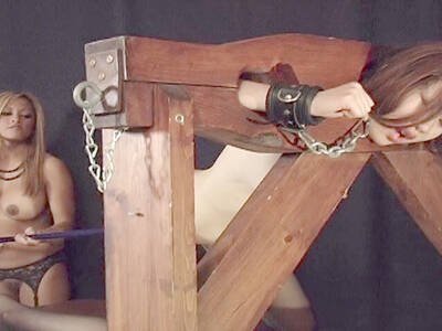 Domina führt einer Asiatin am Pranger einen Dildostab ein